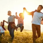 Happy family: mother, father, children son and daughter on nature on sunset